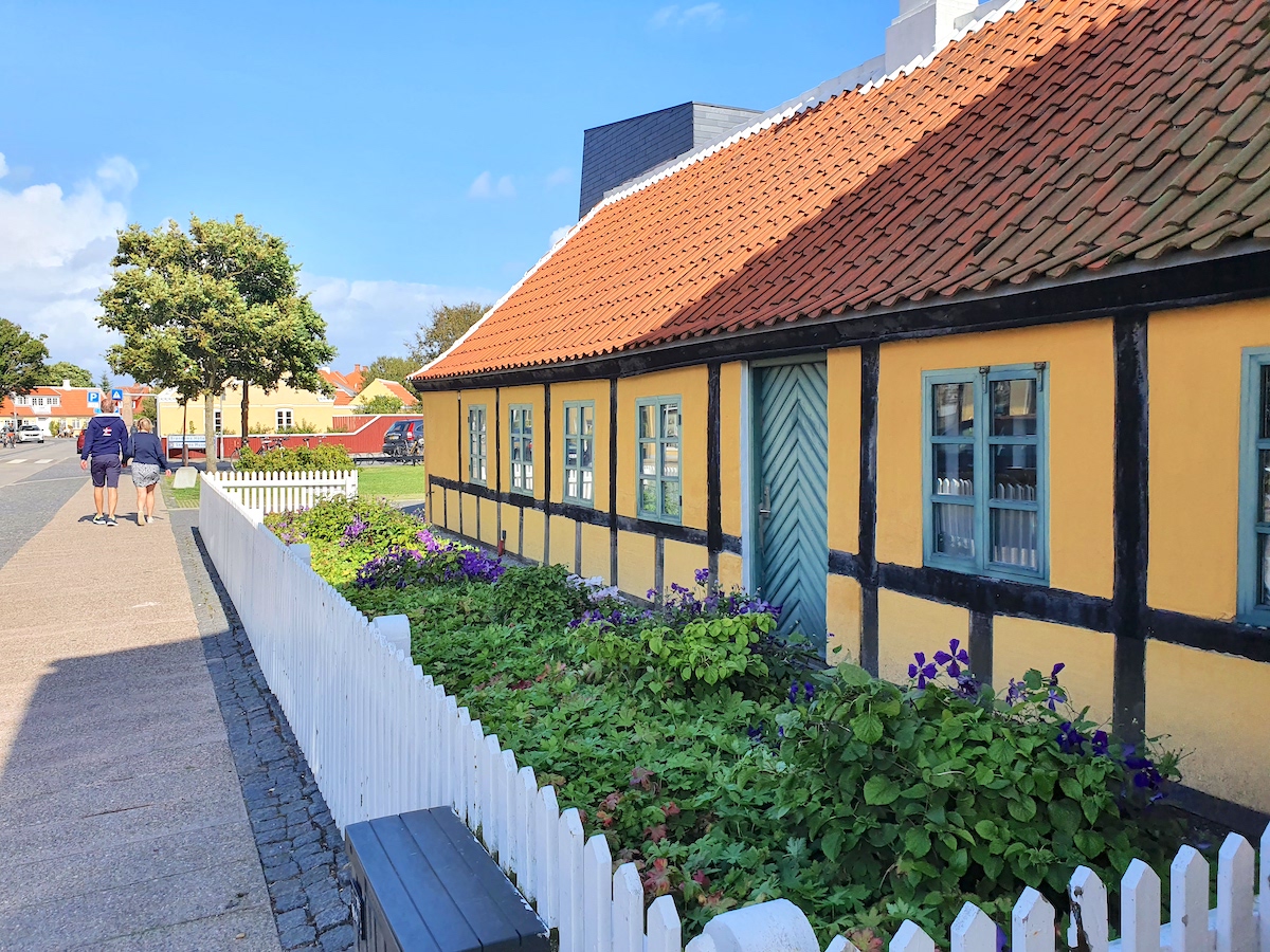 Gelbes Fachwerkhaus mit rotem Dach und weißem Zaun in Skagen – Foto: Birgit Hoffmann